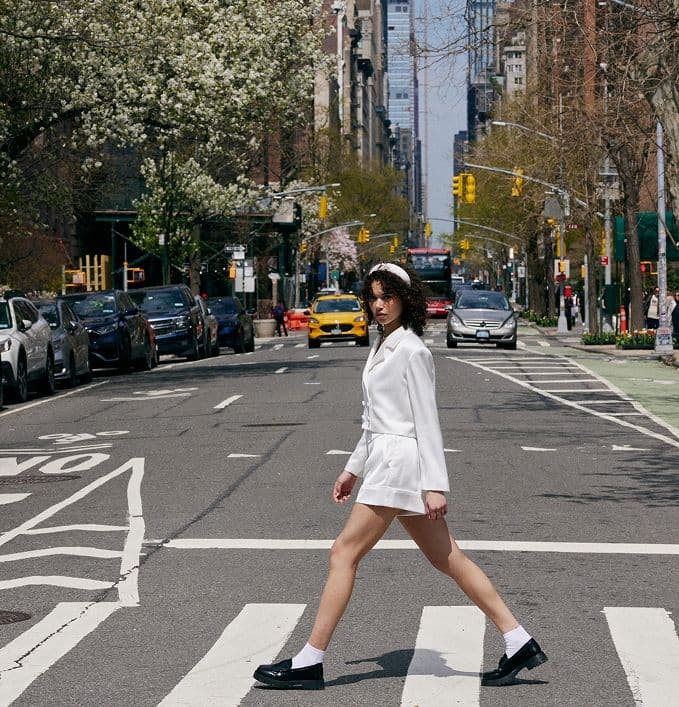 woman in matching set walking across the street
